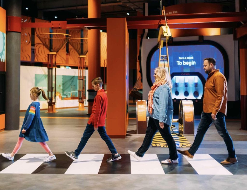 Family walking on zebra crossing at w5