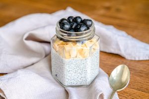 Chair pudding for breakfast with blueberries on a table with cloth and silver spoon