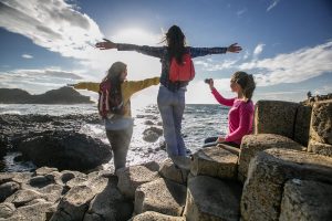 Three girls posing infant of the Giant's Causeway on a sunny day