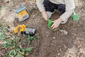 child playing with trucks in dirt