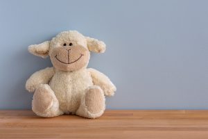 Smiling soft toy sitting on a shelf